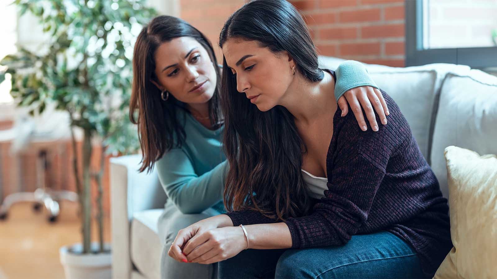 woman helping another sad woman